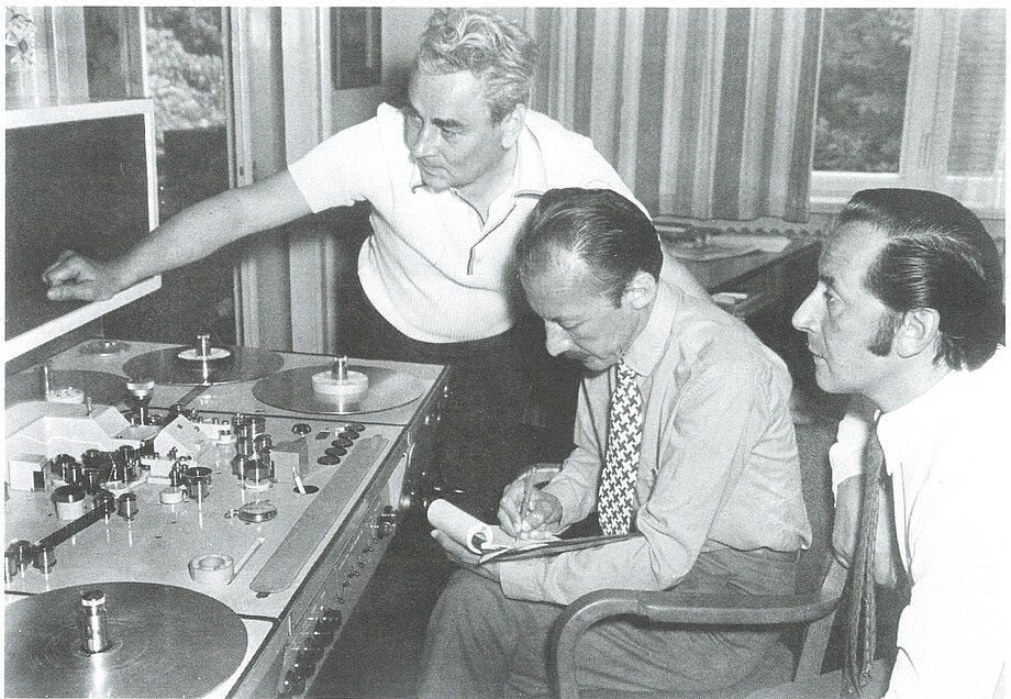 Schwarz-Weiß-Fotografie, auf dem drei Personen an einem Schneidetisch zu sehen sind